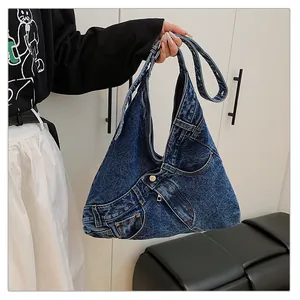 Detail of creative blue denim shoulder bag featuring classic jeans pockets and metal buttons
