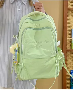 Dettaglio dello zaino in nylon verde menta con ricamo e ciondolo a luna in peluche