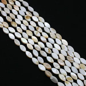 Dettaglio di perle in madreperla naturale a forma di navette con lucentezza dorata