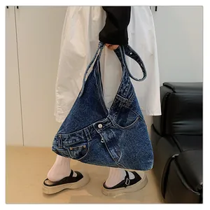Detailed close-up of a denim tote bag featuring jeans-style waist details and buttons