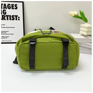 Detail view of grass green nylon backpack with tropical label and drawstring adjustment