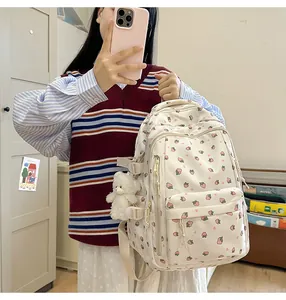 Close-up of strawberry print backpack with a cute plush bear charm on side pocket