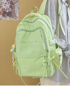 Dettaglio dello zaino verde menta con ricamo e tasche multiple con cerniera laterale