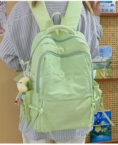 Dettaglio dello zaino in nylon verde menta con ricamo e ciondolo a forma di luna
