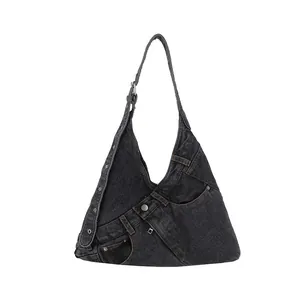 Minimalist deconstructed denim hobo bag in dark grey with orange stitching and metal buckles