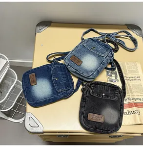 Three retro denim crossbody bags in blue and black colors displayed on a vintage suitcase