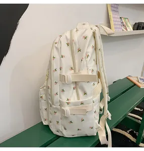Detail of adjustable side straps and white plastic buckles on floral print backpack