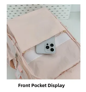 Dettaglio della tasca anteriore dello zaino rosa che mostra la capienza per il telefono