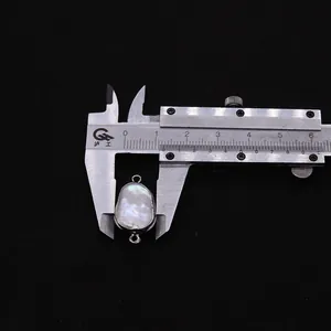 Detailansicht eines Barockperlen-Connectors mit Silberrahmen und Messschieber