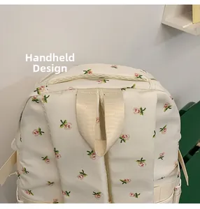 Detail of the reinforced top handle and shoulder strap stitching on floral backpack