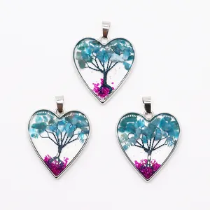 Detailansicht der herzförmigen Lebensbaum-Anhänger mit blauen und rosa Natursteinen