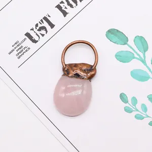 Detailansicht eines rosa Naturstein-Anhänger mit antiker Bronze-Metallfassung