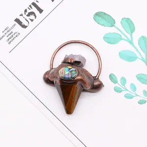 Vue macro du pendentif flèche avec améthyste, nacre d'abalone et pierre œil de tigre