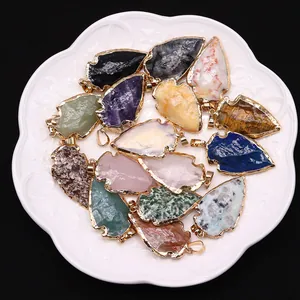 Colgantes de piedra natural en forma de flecha con bordes dorados en plato blanco