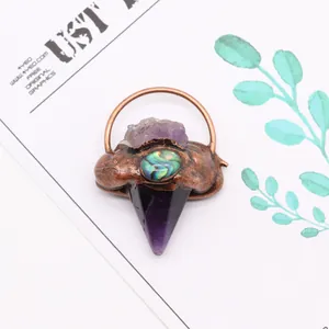 Détail macro du pendentif en pierre naturelle flèche avec améthyste et nacre d'abalone