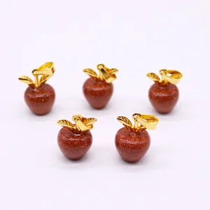 Detail van vijf appelvormige goudsteen hangers met gouden bladbedeltjes voor DIY-kettingen