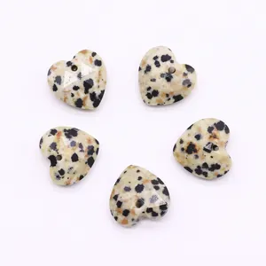 Detailed view of five faceted heart-shaped Dalmatian Jasper stone pendants with drilled holes