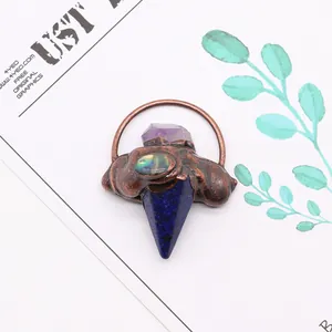 Détail du pendentif en pierre naturelle en forme de flèche avec cristal et nacre