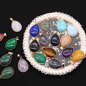 Collection of teardrop natural stone pendants with gold plating on elegant lace tray