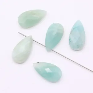 Macro shot of pear-shaped faceted green natural stone beads with fine vertical drill holes