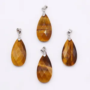 Macro shot of faceted teardrop Tiger Eye pendants with polished silver metal bails