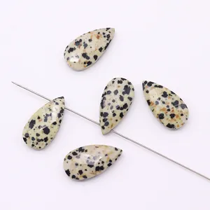 Close-up of teardrop-shaped Dalmatian Jasper bead with vertical hole for DIY jewelry making