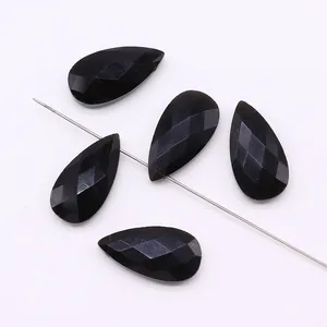 Macro detail of five faceted black teardrop stones strung on a metal pin for DIY jewelry