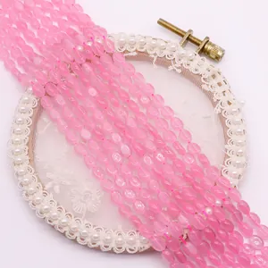 Macro-detail van ovale roze kwartskralen op borduurring voor DIY-sieraden maken