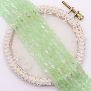Detail van lichtgroene ovale kattenoog kralen op een elegante kanten decoratie
