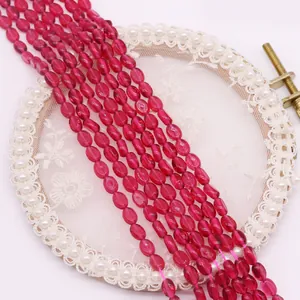 Macro-opname van fuchsia ovale gefacetteerde natuurstenen kralen voor DIY sieraden