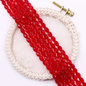 Close-up of faceted ruby red glass beads on white lace for DIY jewelry making