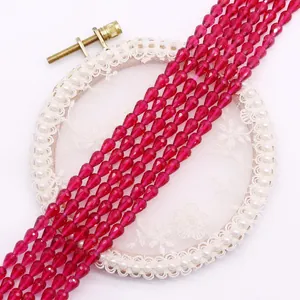 Dettaglio delle perline a goccia in vetro sfaccettato rosso rosa con taglio di precisione