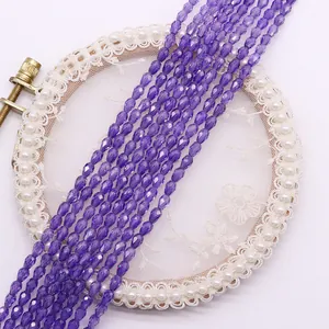 Makroansicht lila facettierter Tropfenperlen auf Spitze für DIY-Schmuck