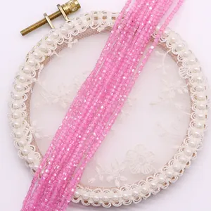 Makroansicht facettierter rosa Kristallwürfelperlen auf Stickrahmen für DIY-Schmuck