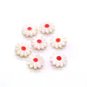 Macro detail of daisy flower shell beads with red center for DIY jewelry making