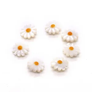 Macro detail of daisy shape natural shell beads with white petals and orange center