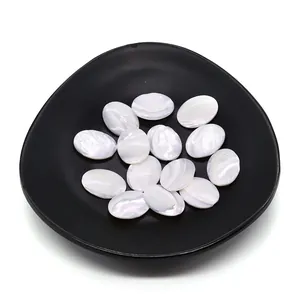 Cabochons ovales en nacre naturelle blanche avec reflets irisés sur plateau de présentation