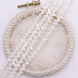 Dettaglio macro di perle in conchiglia bianca su elegante telaio in pizzo