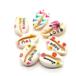 Macro shot of polished cowrie shells with colorful floral patterns and love hope scripts
