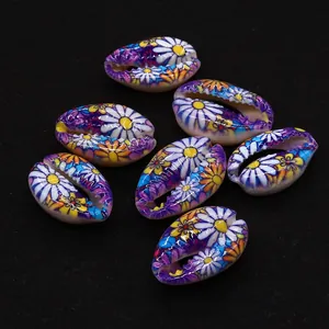 Macro view of colorful floral printed cowrie shells for DIY jewelry making on black background