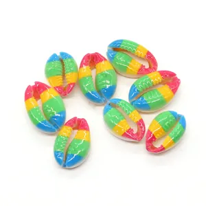 Macro view of nine rainbow-painted natural cowrie shells for DIY jewelry making