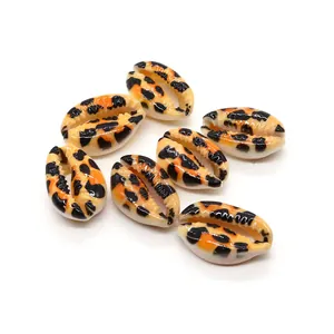 Detalle de conchas naturales pintadas a mano con motivo de tigre naranja para joyería DIY