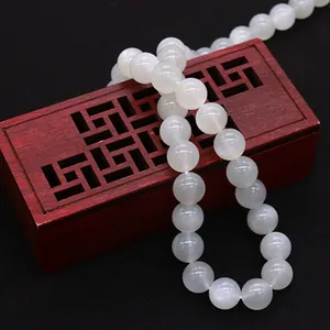 Collana di perle di pietra di luna bianca a forma di S su scatola di legno vintage