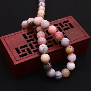 Natural round opal stone beads for DIY jewelry making on a vintage wooden box