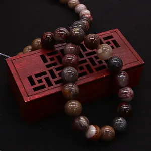 Natural petrified wood stone beads s-shaped on retro box for DIY jewelry making