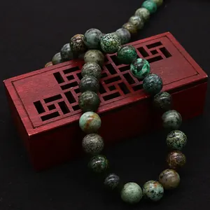 Natural African turquoise stone round beads on a traditional wooden display box for DIY jewelry