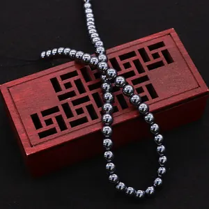 Polished dark grey terahertz gemstone round beads for DIY jewelry making on a wooden box