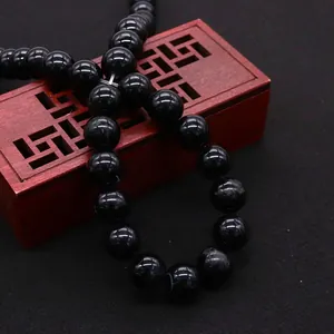 Gepolijste zwarte agaat kralen 10mm op een gesneden houten doos voor DIY-sieraden maken