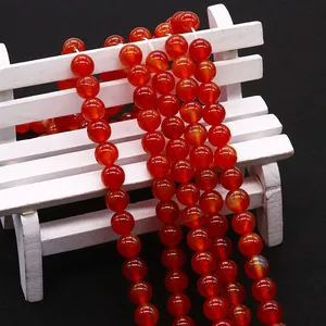 Perle tonde in agata rossa naturale per gioielli fai da te su una mini panchina bianca