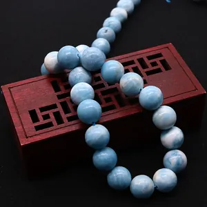Polished natural blue sky stone beads for DIY jewelry making on a vintage wooden stand
